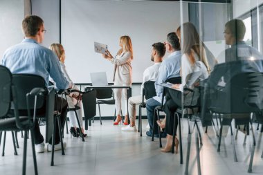 Öğrenciler için yeni şeyleri açıklıyorum. Profesyonel iş adamlarından oluşan bir grup ofiste..