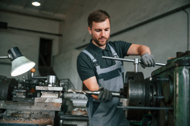 El işi ayrıntıları. Üniformalı adam iş yerinde tarım tekniğinin detaylarını geliştiriyor..