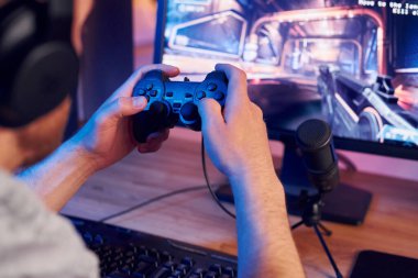 Oyun kumandasını kullanarak. Evde FPS nişancı oyunu oynayan çevrimiçi flamalar.