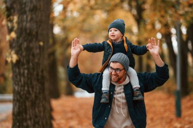 Kalın giysiler içinde. Baba ve küçük oğlu gündüz vakti dışarıda beraberler..