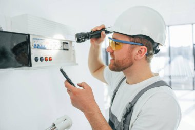 Elektrik sorunları var. Tamirci modern odada kapalı alanda çalışıyor..