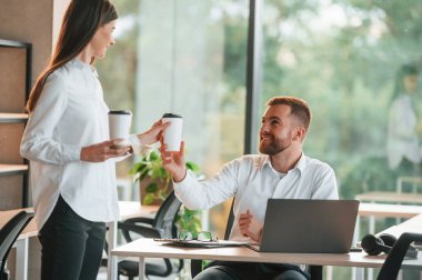 Erkek ve kadın modern ofiste birlikte çalışıyorlar..