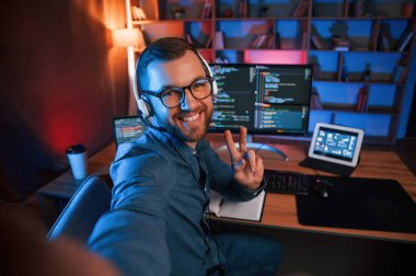 Profesyonel programcı içeride çalışıyor. Neon ışıkları.