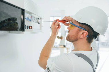 Elektrik sorunları var. Tamirci modern odada kapalı alanda çalışıyor..