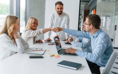 Başarılı bir takım çalışması. Profesyonel iş adamlarından oluşan bir grup ofiste..