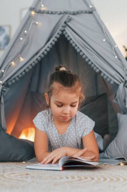 Kitabı okuyordum. Evdeki çadırda oynayan sevimli küçük kız..