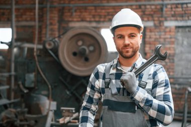 Gri üniformalı ve beyaz şapkalı. Fabrika erkek işçisi içeride..