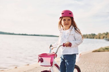 Aktif hafta sonu harcamaları. Mutlu küçük kız yazın dışarıda bisiklet sürüyor..