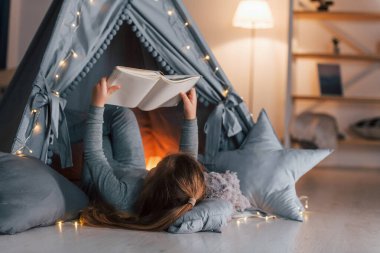 İlginç bir kitap. Evdeki çadırda oynayan sevimli küçük kız..