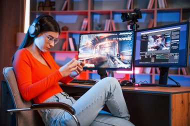 Akıllı telefonu elinde tutarak. Zafer kavramı. Genç ve güzel oyun flaması bilgisayarla birlikte içeride..