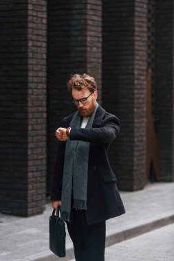 Kontrol zamanı. Sakallı ve gözlüklü şık adam binanın yanında..