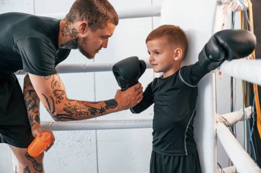 Profesyonel sporun başlangıcında. Koç çocuklara kapalı alanda boks teknikleri öğretiyor..
