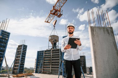Evraklı not defteriyle. Foreman inşaat alanında çalışıyor..