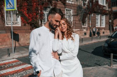 Ayakta durmak ve birbirimizi kucaklamak. Güzel genç çift sokakta eski binaya karşı birlikte..