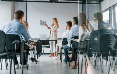 Öğrenciler için yeni şeyleri açıklıyorum. Profesyonel iş adamlarından oluşan bir grup ofiste..