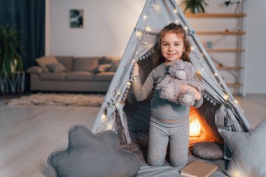 Uyanıyorum. Evdeki çadırda oynayan sevimli küçük kız..