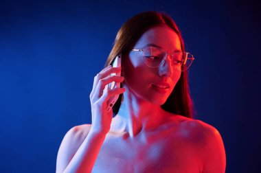 Telefonla konuşuyorum. İçerideki neon ışıkta duran genç bir kadının portresi..