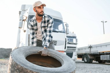 Kırık lastikle. Genç kamyon şoförü gündüz vakti aracıyla geliyor..