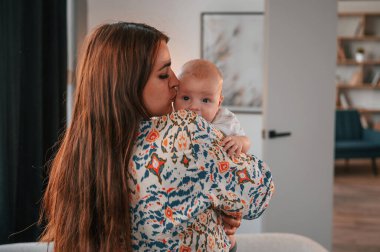 Çocuğu öpmek. Güzel mutlu anne ve yeni doğan oğlu evde..