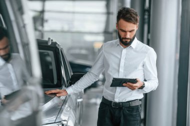 Masa ellerindeydi. Beyaz elbiseli genç adam araba galerisinde..