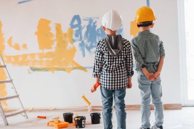 Hayal gücü kavramı, sanat. İki çocuk ev odasında duvar boyuyor..