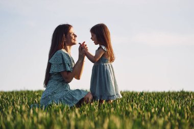 Şefkat anı. Anne ve kızı yazın açık havada eğleniyorlar..
