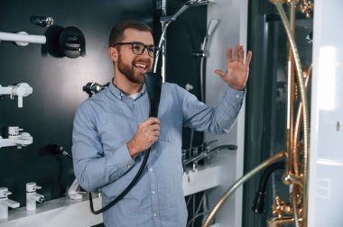 Duş musluğuyla oynamak, şarkı söylemek. Adam hijyenik eşya dükkanından ürün seçiyor..