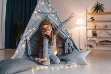 Pilot gözlükleriyle. Evdeki çadırda oynayan sevimli küçük kız..