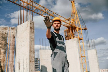 Kes jesti. Üniformalı adam inşaat alanında çalışıyor..