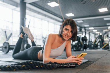 Gündüz vakti. İnce vücutlu spor elbiseli kadın spor salonunda..