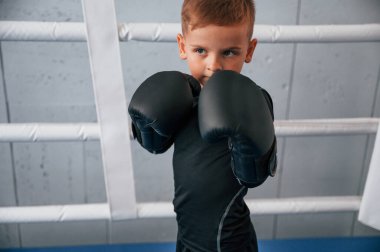 Yüzüğe. Çocuk ellerinde parıltılarla spor salonunda boks yapıyor..