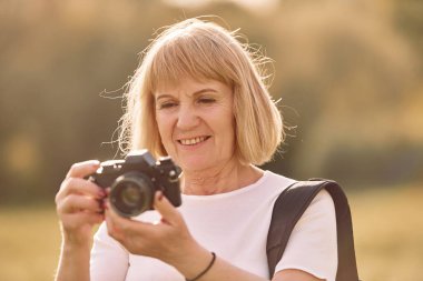 Kamerayı kullanarak. Fotoğrafları hazırlıyorum. Sunny Day 'de son sınıf öğrencisi dışarıda güzel bir hafta sonu geçiriyor..