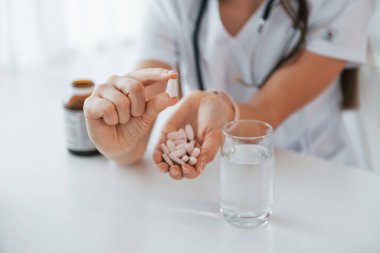 Haplar elinde. Ofiste beyaz önlüklü profesyonel bir sağlık görevlisi var..