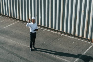 Üst Manzara. Tabletle. Erkek işçi konteynırlarla birlikte olay yerinde..