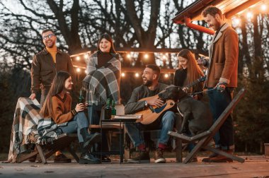 Bir grup insan akşamları arka bahçede birlikte vakit geçiriyorlar..
