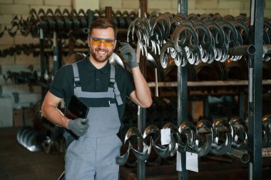 Tabletle duruyorum. Üniformalı adam iş yerinde tarım tekniğinin detaylarını geliştiriyor..