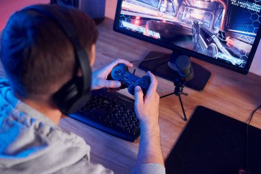 Oyun kumandasını kullanarak. Evde FPS nişancı oyunu oynayan çevrimiçi flamalar.