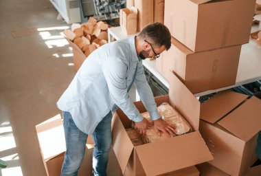 Tahta çarşafları paketliyorum. Beyaz elbiseli matbaacı içeride..