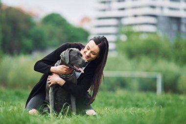 Bakım kavramı. Genç esmer kız köpeğiyle dışarıda yürüyüş yapıyor..