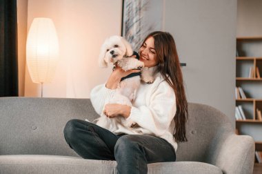 Kanepede oturuyordum. Güzel bir kadın Malta köpeğiyle evde..