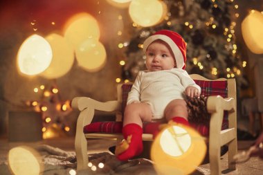 Küçük kanepede oturuyordum. Sevimli bebek evde. Yeni yıl süslemeleri. Tatil kavramı.