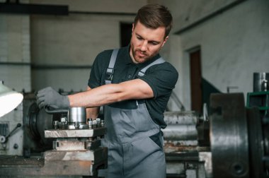 Metalle çalışmak. Üniformalı adam içeride tarım tekniğinin detaylarını geliştiriyor..