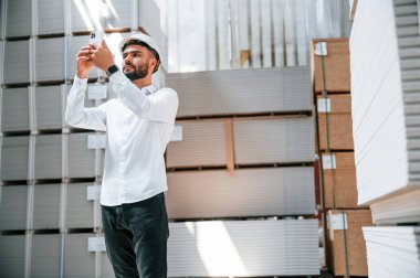 Telefonla. Depo işçisi depoda bir sürü ürünle birlikte..