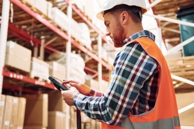 Tableti ellerimde tutuyorum. Üniformalı eleman gündüz vakti depoda çalışıyor..