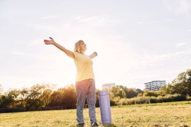 Kolları yanda durarak. Sunny Day 'de son sınıf öğrencisi dışarıda güzel bir hafta sonu geçiriyor..