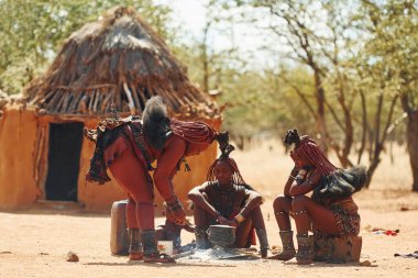 Namibya, Afrika - 14 Haziran 2021: Afrika 'daki etnik halk açık havada. Yetişkin kategorisi. Yakın evler.