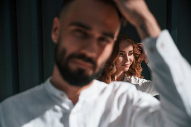 Güzel genç çift koyu yeşil arka planda yan yana duruyor..