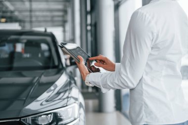 Tablet kullanıyorum. Kadın gündüz vakti otosalonda..