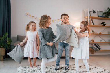 Doğum günü partisinde yastık savaşı. Bir grup çocuk gündüzleri evde birlikteler..