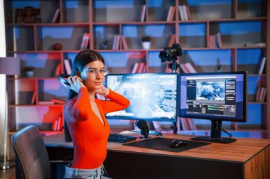 Kulaklık takıyordu. Genç ve güzel oyun flaması bilgisayarla birlikte içeride..